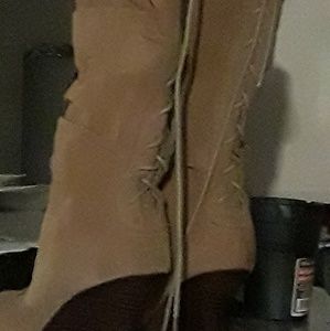 Tan high heel boots that tie up in the back..